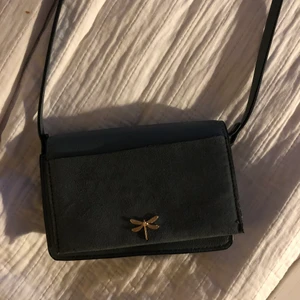 Liten väska  - Supersöt liten väska från HM med en liten trollslända på💕🥺 Har ett fack på utsidan och fack för kort inuti. Kan frakta också (köparen står isåfall för frakten)