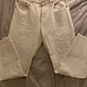Levis jeans  - Ett par creme vita jeans från Levis. Lite uttöjda i midjan på mig. Jag är 166 cm och dom sitter vid mina fotleder. Dom är slitna på slutet och man knäpper dom med knapar 