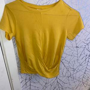 En oanvänd gul t-shirt med en knut 