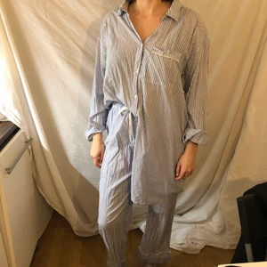 Pyjamas  - En vit och blå randig pyjamas i storlek L. Frakt tillkommer på 50 kronor.