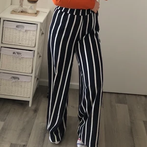 Randiga kostymbyxor - Ett par marinblå kostymbyxor med vita ränder som endast är använd 2 gånger. Sömmen på fickorna är inte ens öppnade precis som ett par nyköpta kostymbyxor. De är i storlek 36 men jag skulle säga att de skulle passa en 38a också. Väldigt luftiga och är i en jättefin material. Jag är 163cm lång. Ordinarie pris: 599kr 