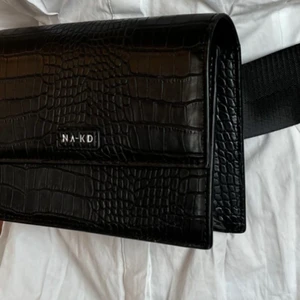 Belt bag Nakd - Svart midjeväska från nakd i ormskinnsmönster. Fint skick. Säljer då jag inte använder den längre. 
