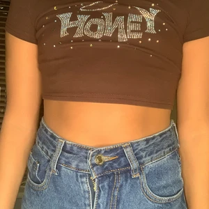 bruna magtröja med text HONEY - brun magtröja med text HONEY på. Alla plast deamanter är kvar, den är även bara använd två gånger bå en av dem var när jag tog bilden😀.