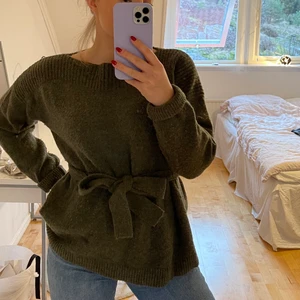 Khakigrön stickad tröja - En fin stickad tröja med knyt i midjan, i väldigt mjukt material. Knappt använd. Säljer för 250 kr eller högstbjudande. Köparen står för frakten. 