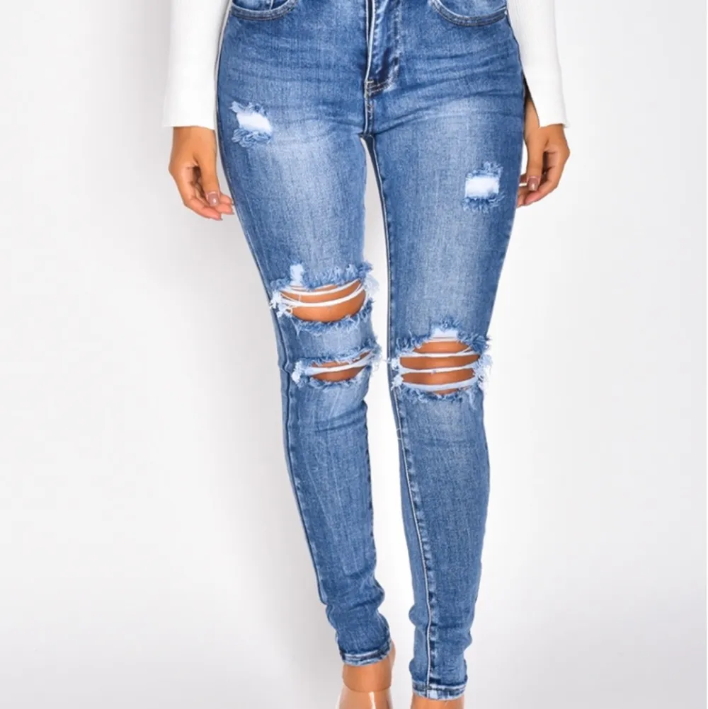 Snygga jeans med hål i storlek S, mörkblå färg som är snygga och är mellanmidjade. Helt OANVÄNDA. Bra material och sitter väldigt snyggt på. Passar alla längder och former!. Jeans & Byxor.