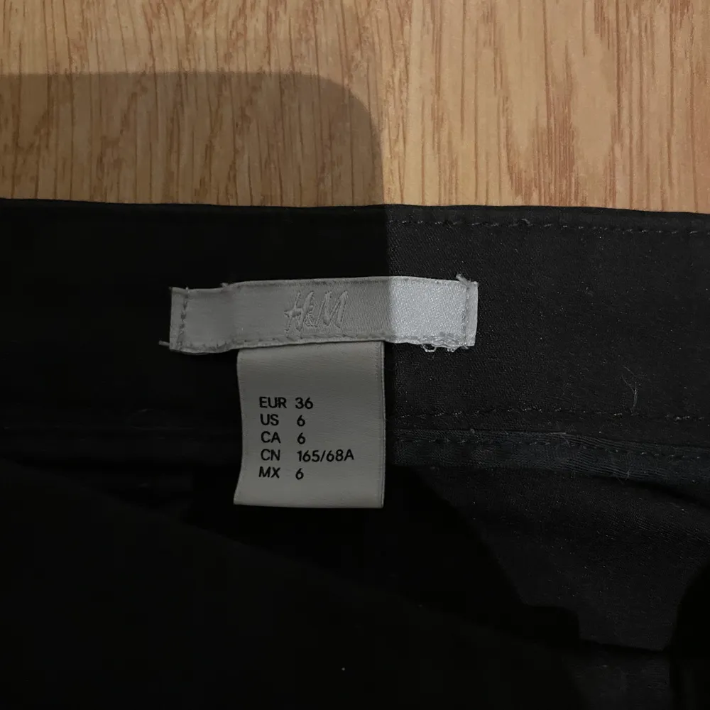 Svarta tajta kostymbyxor från H&M med slits i benet. Köparen står själv för frakten . Jeans & Byxor.