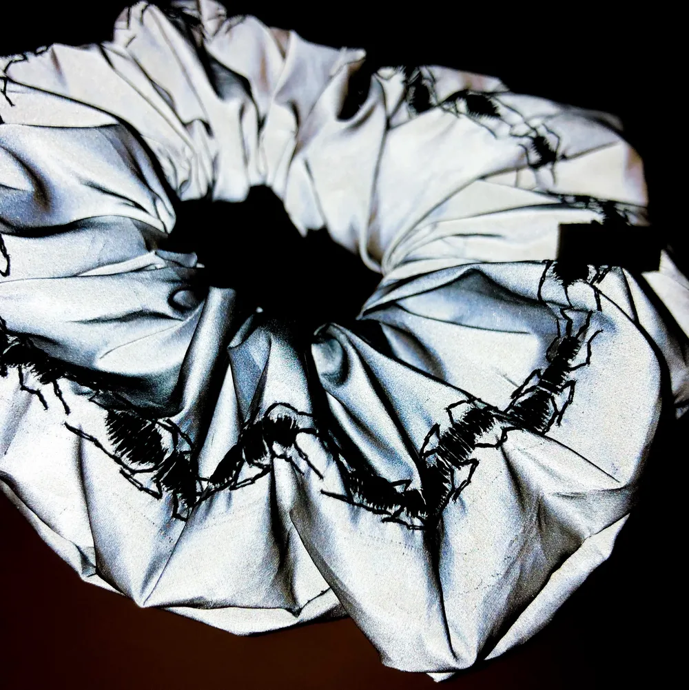 Ascool reflexscrunchie med svarta broderade myror på. Perfekt på dansgolvet, halloweenfesten eller under kvällsjoggningen.. Accessoarer.