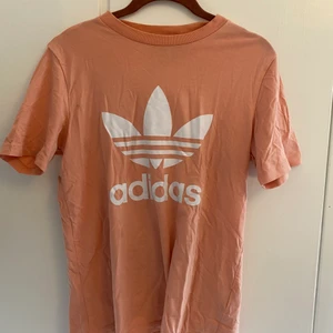Adidas t-shirt - Jätte fin rosa t-shirt från adidas som jag använt kanske 5 ggr. Har en liten fläck ( se bild 2) som jag inte vet hur jag fått men kanske går att ta bort? Säljer pga att jag knappt använder. Köparen står för frakten, pris kan diskuteras. Kom priv för föer bilder<3 sitter ganska oversize och bör passa xs-l beroende på hur du vill att den ska sitta