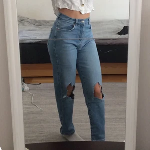 Blåa jeans  - Snygga blåa jeans från Gina tricot med slitna knän och detaljer. Väldigt stretchigt och skönt material. Storlek 38 men passar även bra på 36. 