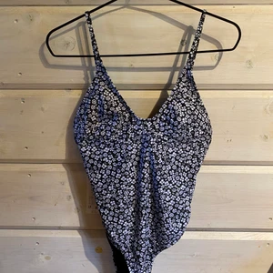 Baddräkt Vero moda - Blå baddräkt med blommigt mönster, låg rygg och knyte i bak. Aldrig använt. Kan mötas upp eller du står för frakten 😇
