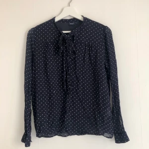 Prickig knytblus  - Snygg prickig mörkblå knytblus i storlek 36 från Park Lane. Fint skick!