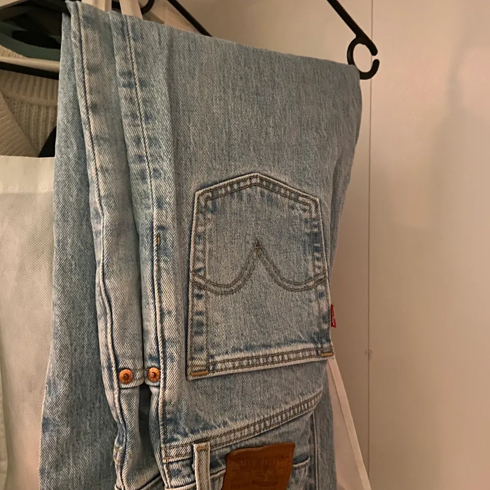 Säljer blåa Levis jeans i ”ribcage straight ankle” i storleken 23/27! Använda men i superbra skick!. Jeans & Byxor.