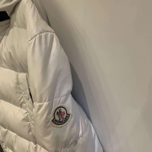 Fin och fräsch monclear jacka  - Vit monclear jacka, använt några gånger och är i bra kondition. Inga håll i den. Den är ganska varm. Den kommer med äkta päls och et bälte som man har runt midjan 