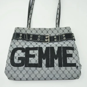 Gemme🌟 by M.E.J UF - En grå medelstor väska med svarta broderade bokstäver på. Väskan har även ett svart band på framsidan och svarta stora målade bokstäver. ”Gemme” betyder pärla på franska. 
