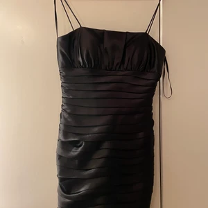 Svart tajt klänning - Svart tajt klänning i glansigt material. Passar storlek xs/s och är inte använd. Säljs för 220kr. Passar perfekt till festligare tillfällen