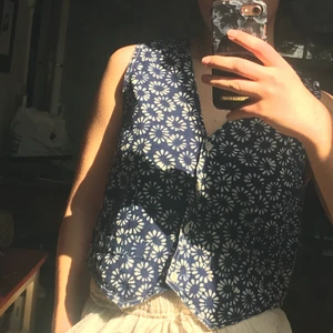 Blå väst  - En gullig blå väst med små vita blommor och vit rygg 