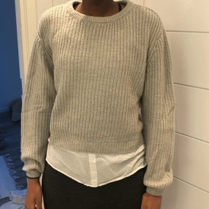 Stickad tröja med blusdetalj - Grå stickad tröja med blusdetalj. Storlek 170. Mysigt material och sticks inte. Aldrig använd.