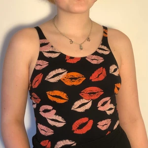 Body - Svart stringbody med läppmotiv och justerbara band<3 Begagnad i superbra skick! Köpt på Bik Bok. Strl. S, men funkar även för XS