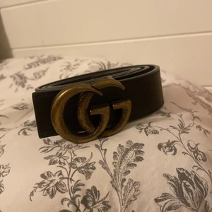 Skärp  - Skärp i brunt läder med GG märke. 105 cm lång🤎