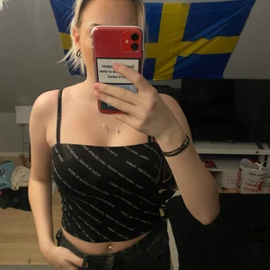 Svart linne från ginatricot  - Ett svart linne med vit text på i storleken S. Använd ganska ofta men i bra skick