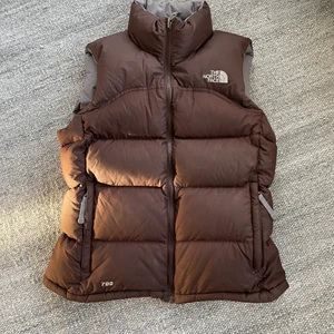Brun north face väst  - En rare brun north face väst i väldigt bra vintage skick! Storlek M dam, personen som budat 1600 innan jag starta budgivningen leder! HÖJ BUD MED MINST 50! lycka till
