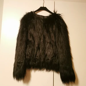 Långhårig fuskpälsjacka - Långhårig fuskpälsjacka. Saknar storlek, men skulle gissa på storlek M (passar öven mindre). Knäpps med hyska och hake. Köparen står för frakten, men vet inte exakt kostnad nu. 