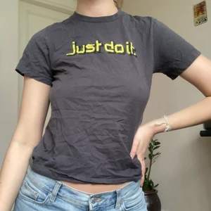 Nike babytee  - Mörkgrå t-shirt från Nike. Det står storlek M men antar att det är barnstorlek för den passar som xs-m beroende på hur man vill att den ska sitta :)