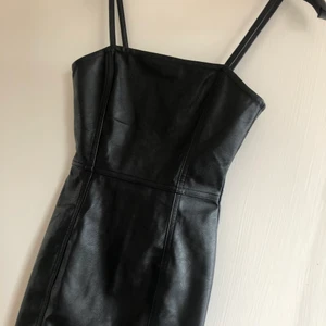 Svart klänning i läderimitation  - Klänning från H&M. Inköpet för ett par år seden. Använd ett fåtal gånger. Säljer den pågrund av att den är för liten 