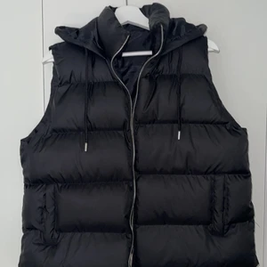 Svart väst - En fin svart väst med en luva! Har en krage samt snören som hänger ner! Super snygg och skön