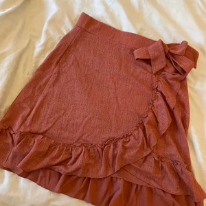 Volangkjol med knut  - Säljer min jättefina rosa volangkjol som är köpt inne på Gina. Kjolen är i jätte fint skick. Den är helt defektfri!  Står inte för frakten!