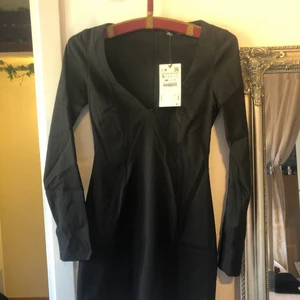 Sprillans-ny svart klänning från Zara - Köpte till nyår men hittade sen en annan och glömde lämna tillbaka 😅Hoppas någon annan får användning av denna! Om det ska fraktas står köparen för frakten 😊 (den slutar strax över knäna)