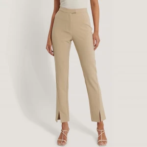 Beiga byxor från NAKD -  Stretchiga byxor i storlek 36 med slits framtill. Är oanvända och endast testade enstaka gånger.