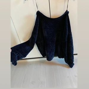 Stickad tröja  - Mörkblå stickad tröja i väldigt mjukt material. Urringad rygg. Fint skick. Köparen står för frakt. 