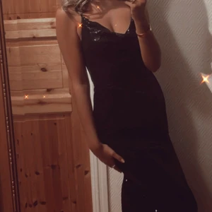 Svart balkläning - Jättefin svart paljett balklänning. Bara använd vid ett tillfälle så som ny. Från asos. Skriv gärna om du vill ha fler bilder. Jag är 164cm och på mig går den till golvet. Är en  slits i bak. Frakt på 66kr tillkommer. 