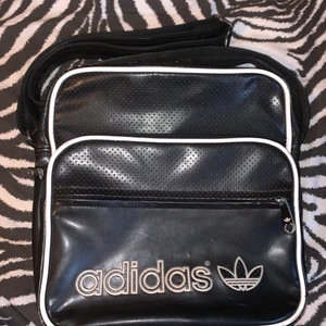 Adidas väska  - En härlig adidas väska i läder. Den har flera fickor och är ren inuti pga att den inte har använts sparsamt. 