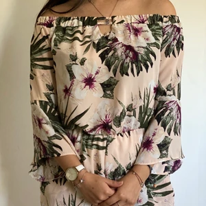 Of shoulder shortsdress - Ljusrosa och blommig of shoulder shortsdress. Använd men i gott skick! 