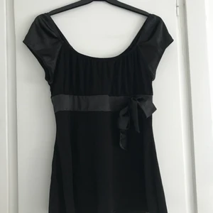 Söt babydoll topp - SÄNKT PRIS!!!! En svart topp i 00s stil, med små puffärmar och band under bysten som knyts i en rosett 😍🎀 Under bandet är toppen liksom lös och svänger lätt utåt, lite babydoll stil 💖 Såå söt, superfint skick! Storlek M men passar nog S också 🌸💕🌼 