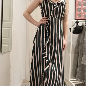 Long dress with ruffles - Zipper on one side. 100% polyester. 