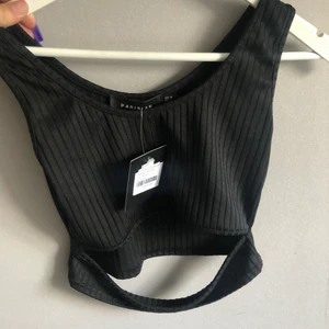 Crop top - Oanvänd crop top från Nelly, ribbad med slitt under bysten. Lappen sitter kvar, storlek 38. Nypris 149kr 