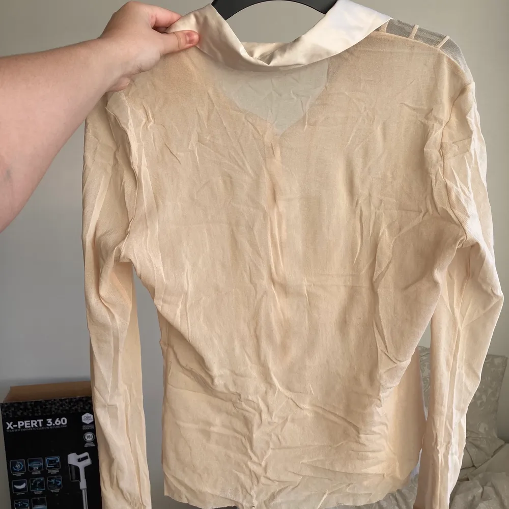 Söt liten blus i ljust beige färg. Uppskattad till storlek M, men är väldigt stretchig. Blusen är transparent med silkesliknande detaljer och krage. Jag samfraktar gärna, ansvarar inte för postens slarv!. Blusar.