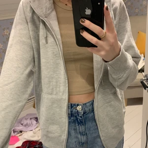 oversized kofta - En ljusgrå oversized kofta med luva och dragkedja 