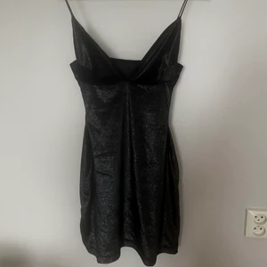 Svart klänning - Svart kortklänning som jag sytt själv. Tyger är valvet glittrigt. Skavanker finns. Säljer för 60kr + frakt. Totalpris: 112kr