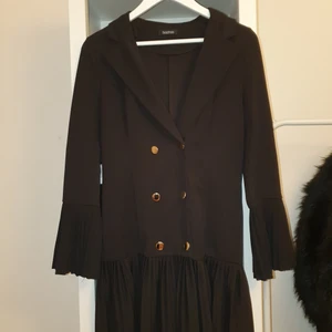 Kavajklänning storlek 38/40 - Svart kavajklänning med guldknappar köpt från Boohoo. Använd 1 gång. I bra skick. 