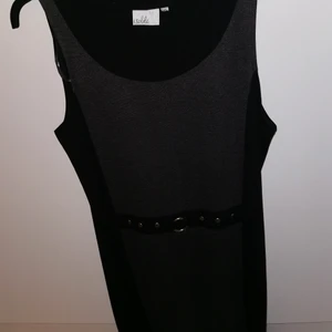 Midlång klänning - Klänning med svart baksida och på framsidan är den grå med skärpdetaljer. I väldigt skick. 