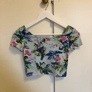 Blommig Crop Top - Kort topp från H&M i storlek XS. Den vita delen har blivit lite blå. Knappt använd, samfraktar gärna.