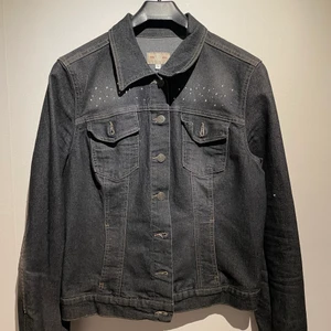 Mörkgrå jeans jacka  - Mörkgrå jeans jacka med kristaller fram och bak. 