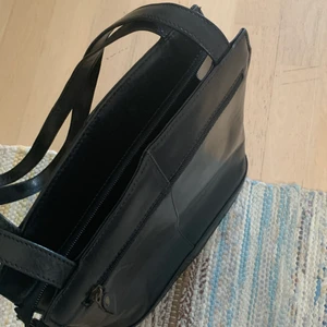 Handväska  - En lite längre handväska i läder som rymmer mycket. Många fack i och lätt att ta med sig 😊