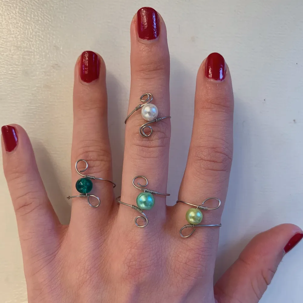 Ringar i silver med virvlar och olika pärlor🥰 Alla är justerbara, och färgerna som finns är grön(olika nyanser), lila, vit✨. Asusteet.