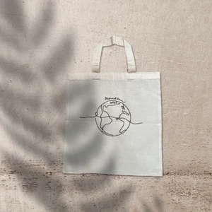 Vacker tygväska  - En tygväska med motiv av en jord och texten ”Natural Aura”.💞 Trycket är givetvis egendesignat och egenmålat.❤️ Väskan finns i två storlekar: Den större varianten: 38x42cm  115kr Den mindre varianten: 27,5x30cm  89kr Frakten är alltid gratis!🥰