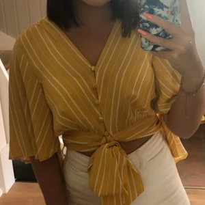 Gul Blus/topp Gina Tricot - Så fin gul- och vitrandig blus/topp från Gina Tricot i storlek M. Den är använd men i fint skick! Köparen står för frakten. 